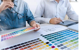 Two men in Magog look at color palettes. There is an architect's plan on the table
